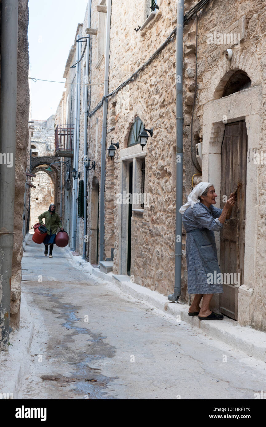 Une femme âgée dans son ancienne maison dans une ruelle dans le village médiéval de Pyrgi, Chios, Grèce. À Chios Pyrgi est connu sous le nom de "village peint Banque D'Images