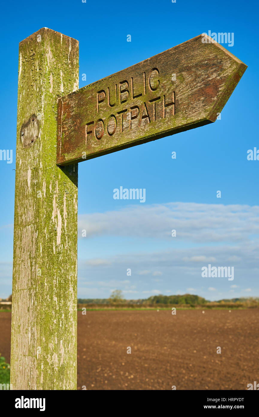 Un fingerpost bois signe indiquant un sentier public droit de passage, contre un ciel bleu. Banque D'Images