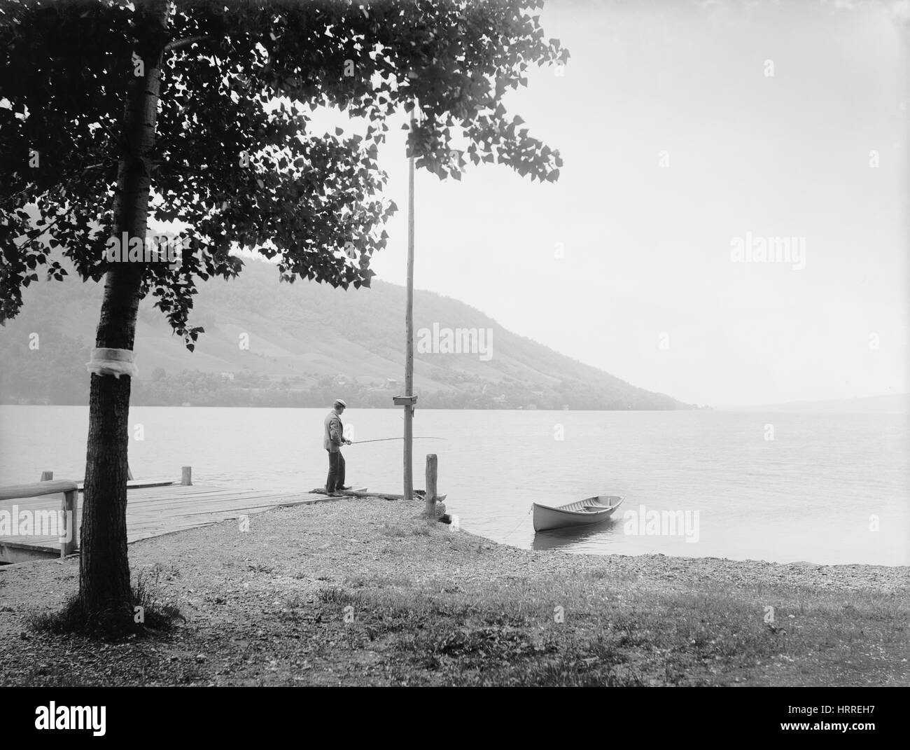 L'homme Pêche sur le lac, Quai Skaneateles, New York, USA, Detroit Publishing Company, 1900 Banque D'Images