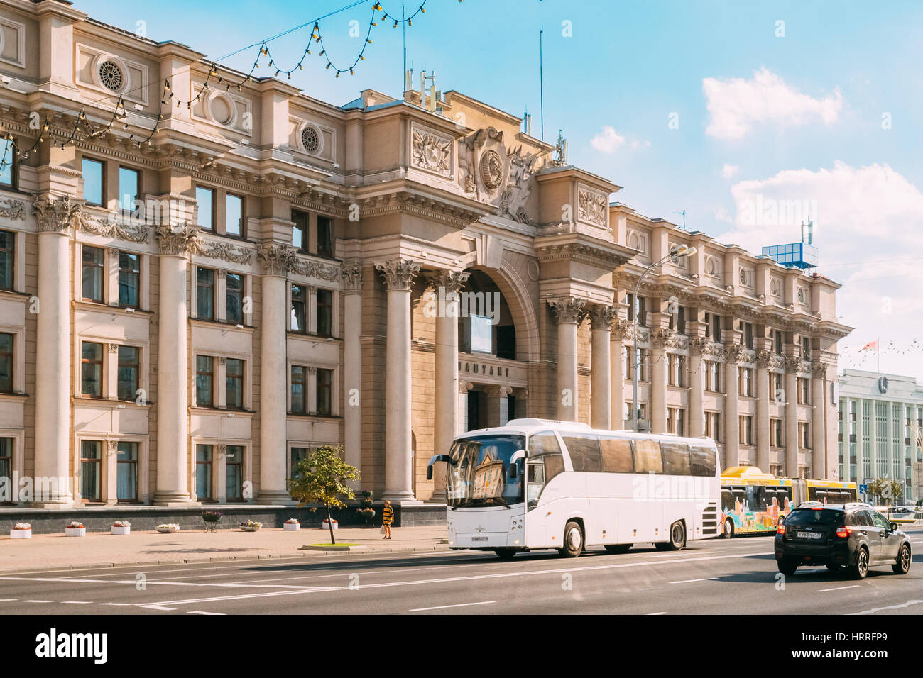 Le Bélarus Minsk. Vue gauche du bureau de Poste Principal bâtiment, construction monumentale de style Empire stalinien ou classicisme socialiste, Bus touristiques blanc Banque D'Images