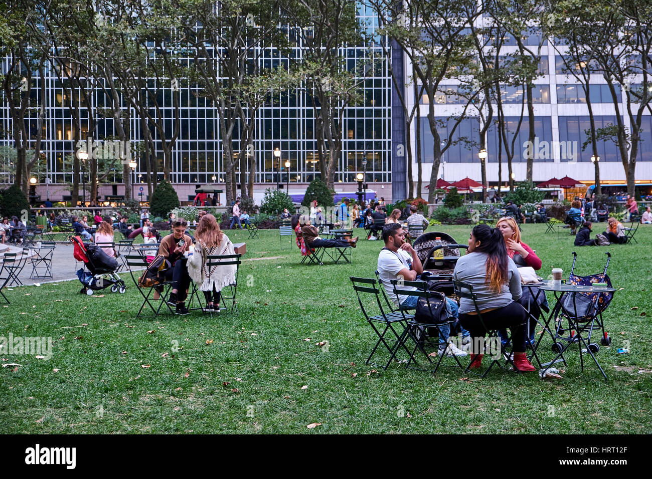 NEW YORK - 26 septembre 2016 : des gens assis dans Bryant Park à petit café tables et chaises, de boire et manger Banque D'Images