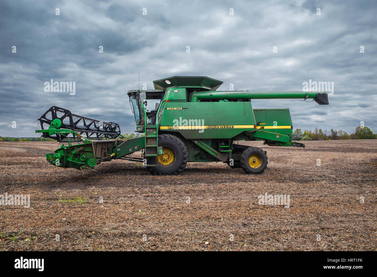 Région de Kiev, Ukraine - Octobre 6, 2013 : John Deere 9610 Maximizer moissonneuse batteuse sur le champ après la récolte de soja avec ciel nuageux sur le backg Banque D'Images