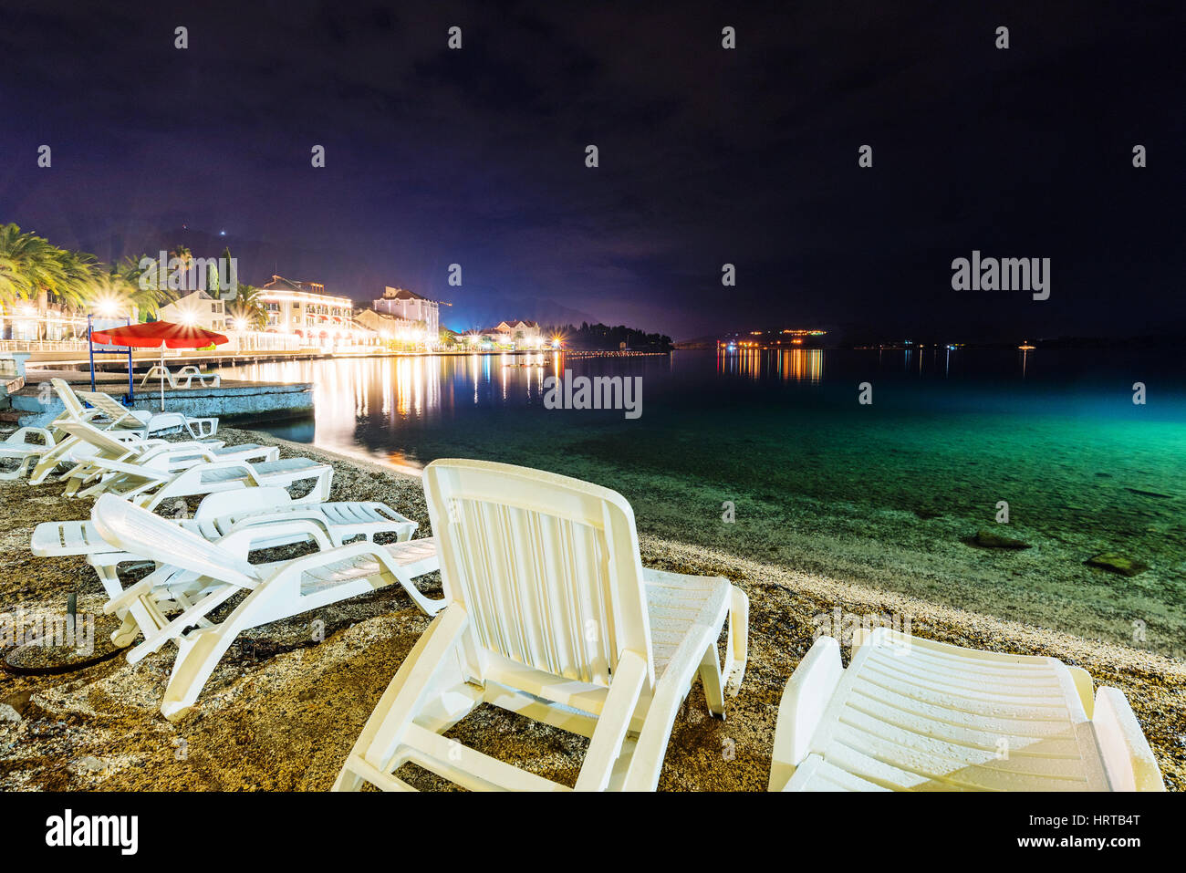 Chaises longues sur une plage de nuit Banque D'Images