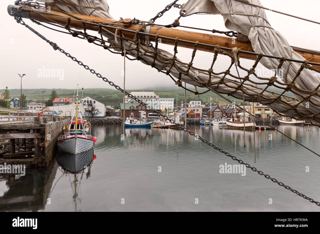 Husavik, l'Islande - bateaux de pêche colorés amarrés au port pittoresque en lumière tamisée Banque D'Images