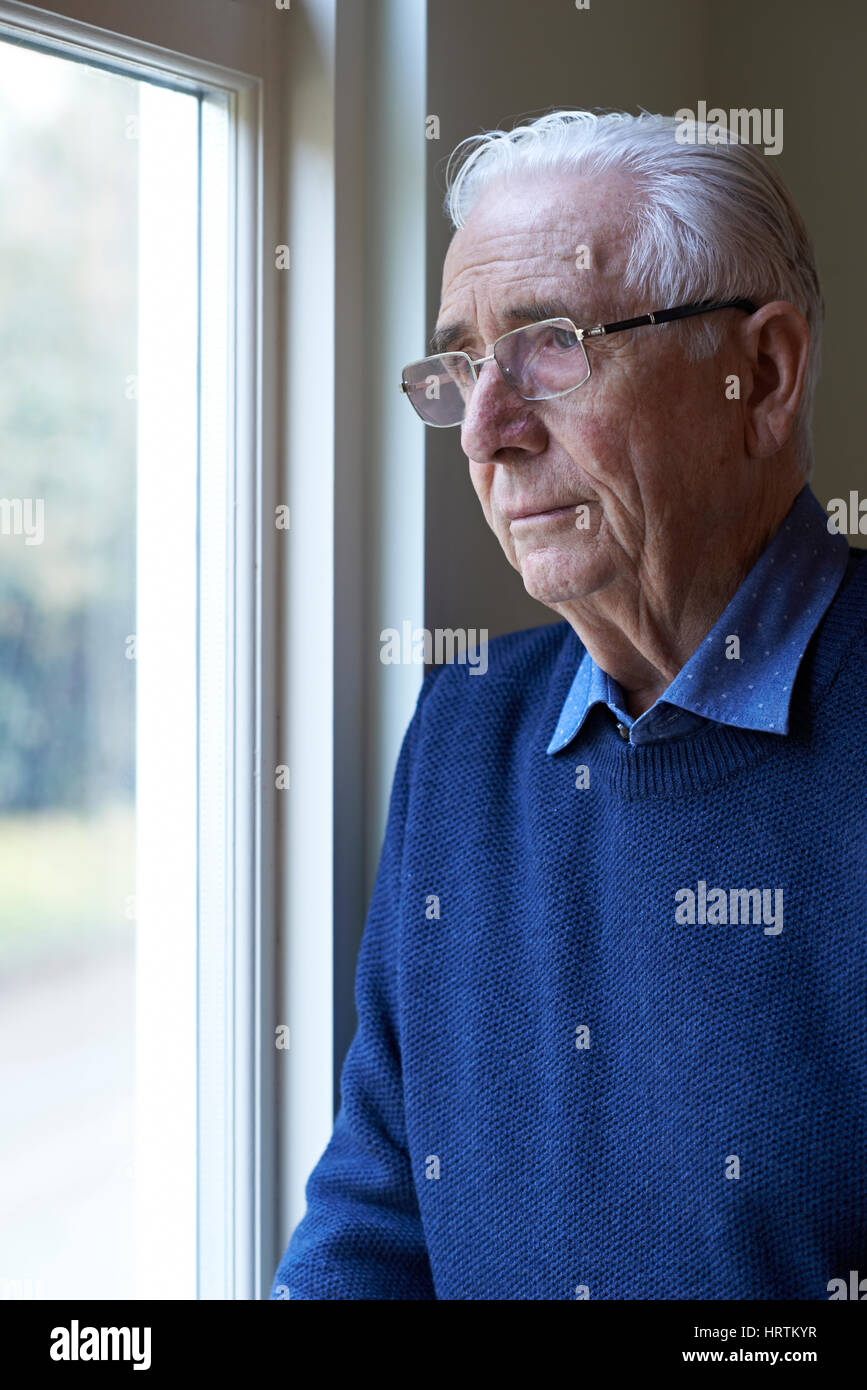 Les hommes qui souffrent de dépression à la fenêtre de Banque D'Images