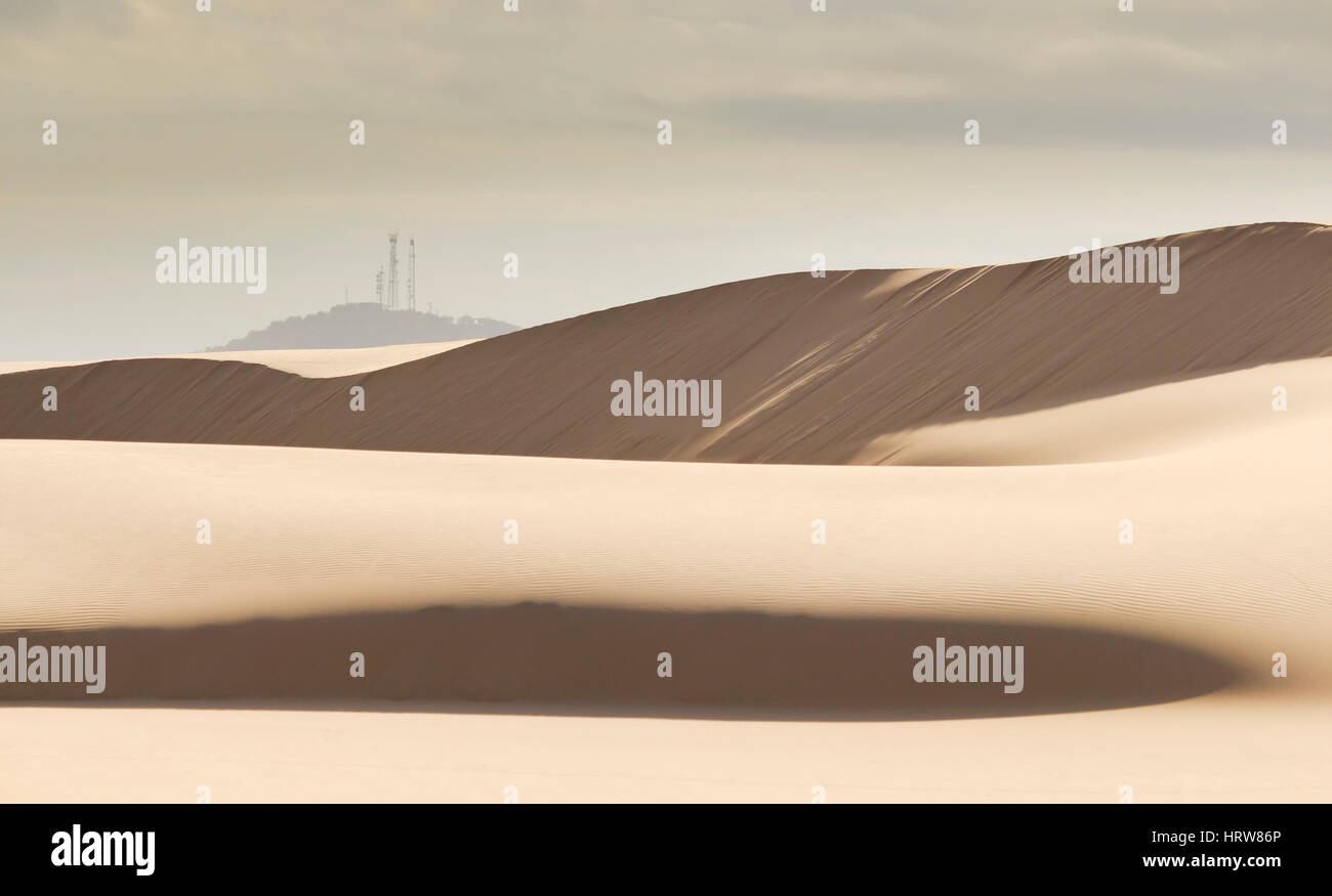 Désert vide paysage de dunes de sable près de Stockton Beach en NSW, Australie, avec des dessus de colline couvertes par des antennes de télécommunications. Banque D'Images