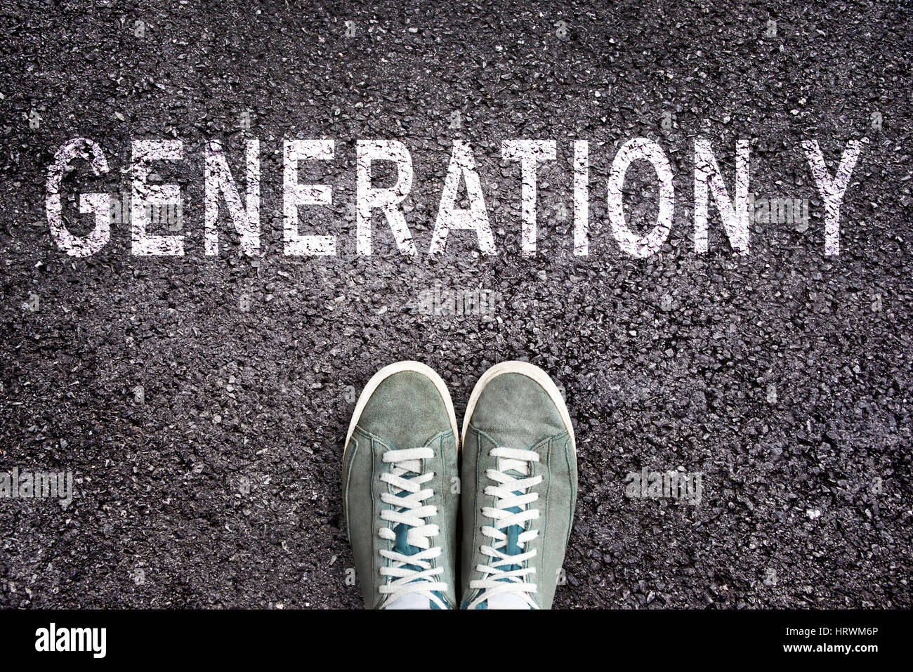 La génération Y du texte écrit sur l'asphalte avec des chaussures Banque D'Images