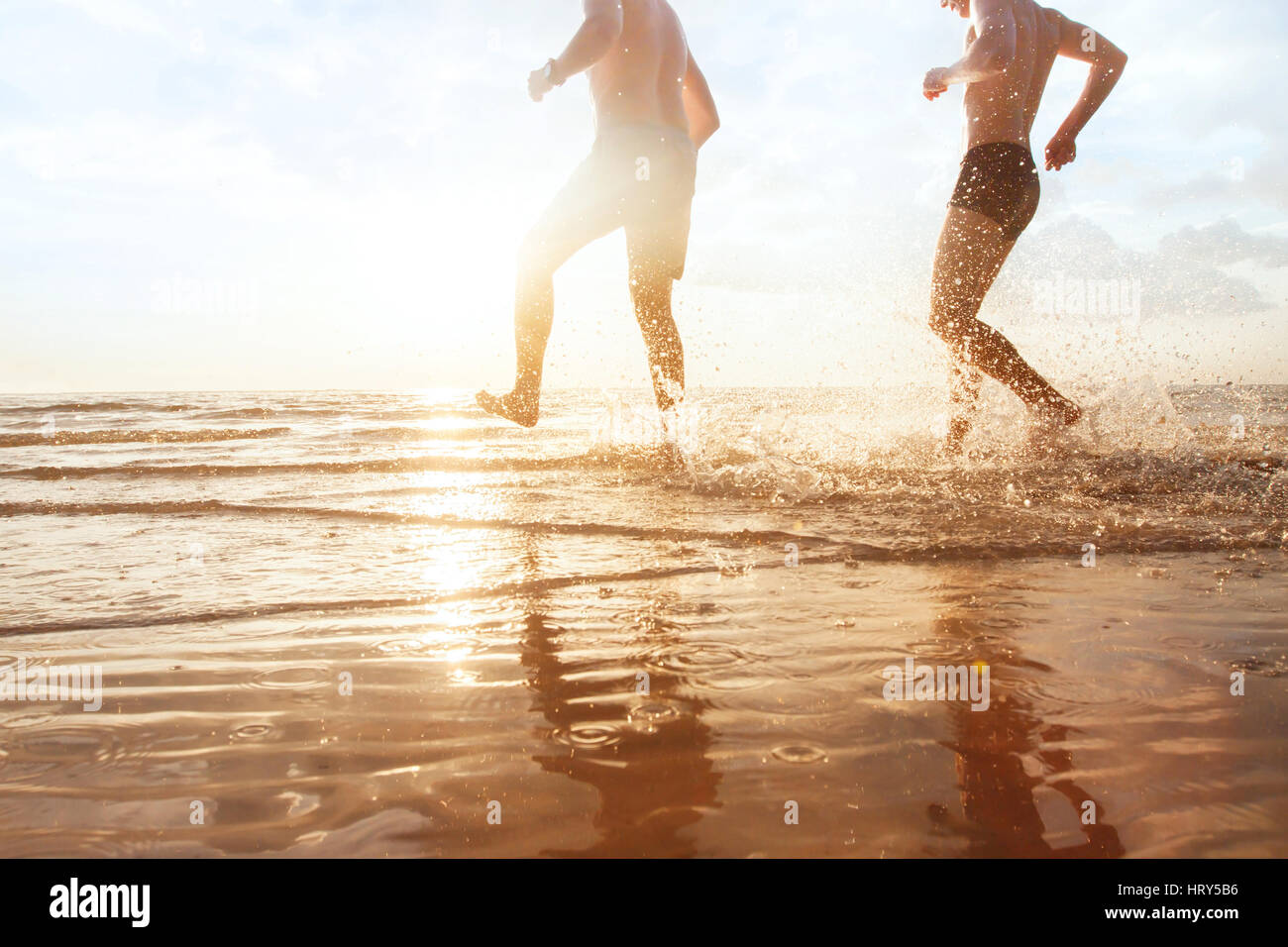 Les amis de s'amuser dans la mer au coucher du soleil plage, enfance heureuse Banque D'Images