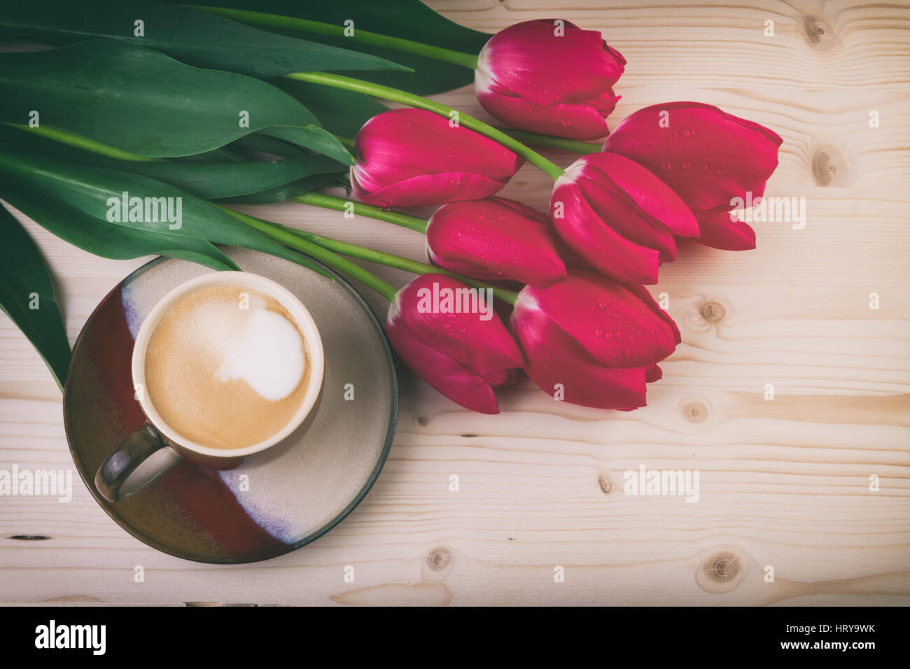 Tasse de café avec fleurs de printemps tulipes rouges sur la table en bois. Style Vintage Banque D'Images