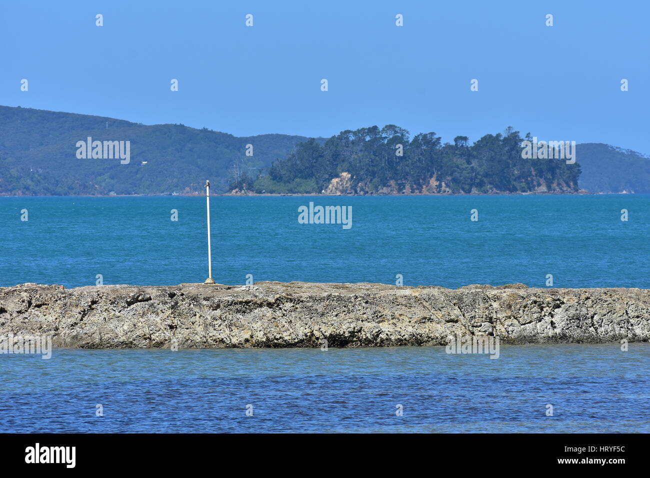 Béton vieux wave breaker entouré par une eau bleue. Banque D'Images