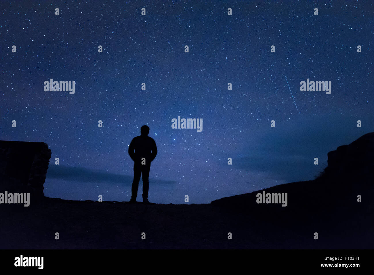 Homme debout sous les étoiles la nuit - Cornwall, uk Banque D'Images