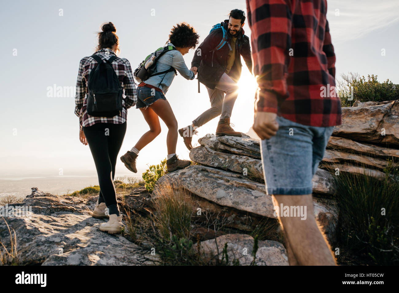 Groupe de randonneurs avec des sacs de marcher sur une montagne. Quatre amis, faire une excursion dans la nature. Banque D'Images