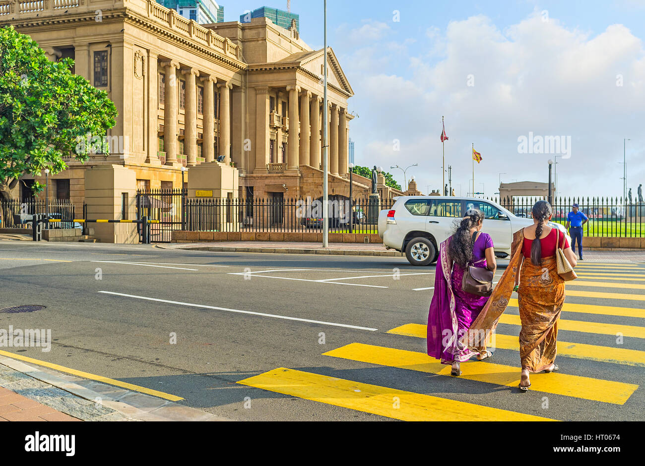 COLOMBO, SRI LANKA - 6 décembre 2016 : Les femmes en sari traditionnel robes à pied de l'autre côté de la rue à l'immeuble de bureau du Secrétariat présidentiel Banque D'Images