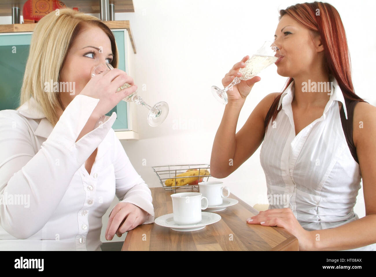 Zwei junge Frauen trinken gemeinsam Sekt an der Kuechenbar - deux jeunes femmes de boire du vin mousseux Banque D'Images