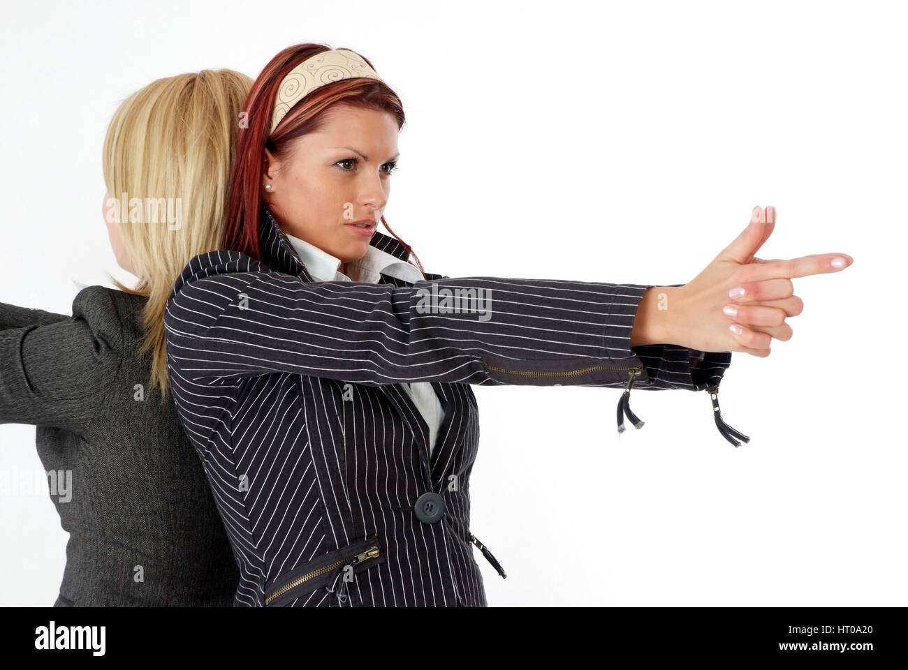 Un Geschoeaeftsfrauen imaginoeaerer Ruecken Ruecken mit la main Schusswaffe in der - les femmes d'affaires à l'occasion d'arme en main fictif Banque D'Images