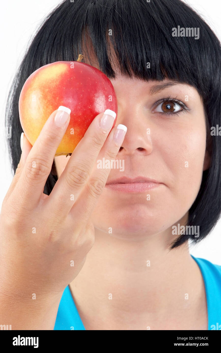 Schwarzhaarige, junge Frau mit Apfel vor dem gesicht - Femme avec Apple Banque D'Images