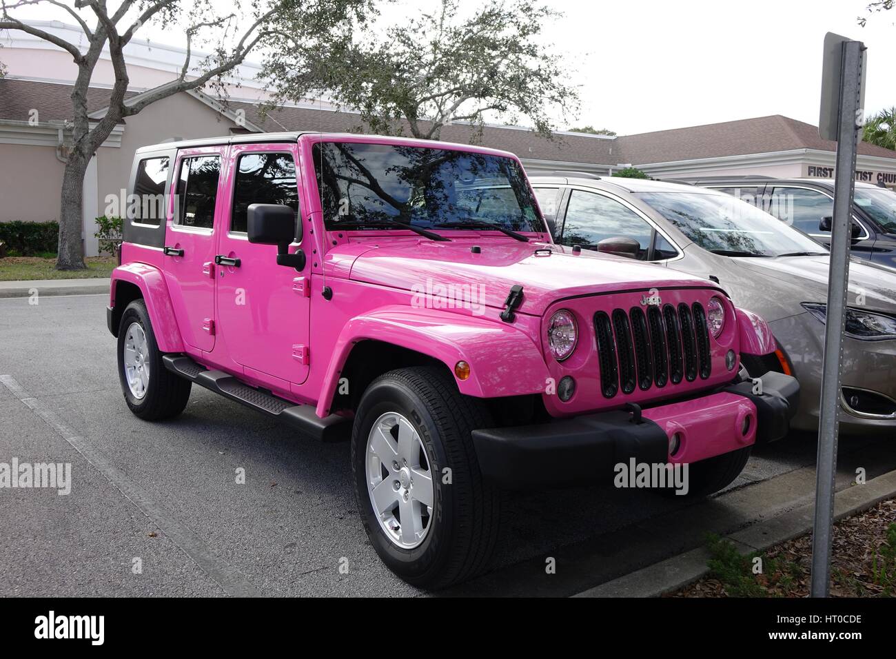 Jeep rose dans un terrain de stationnement public Banque D'Images