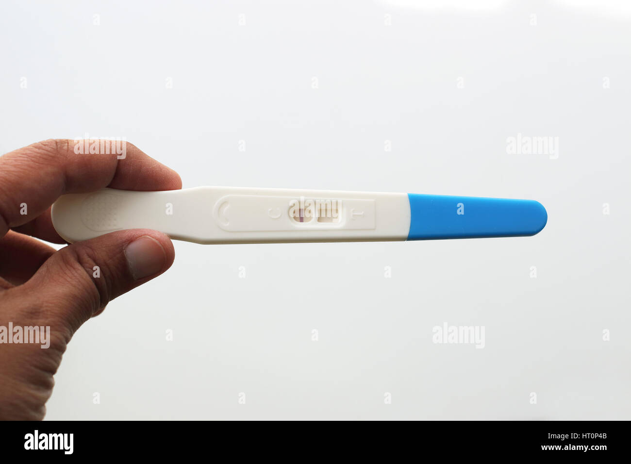 Hand holding Test de grossesse contre isolé sur fond blanc Banque D'Images