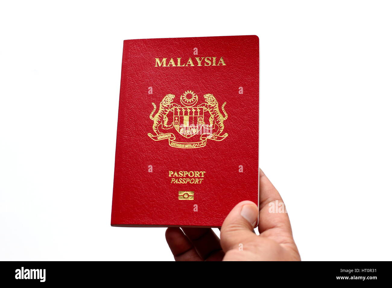 Main tenant passeport malaisien contre isolé sur fond blanc Banque D'Images