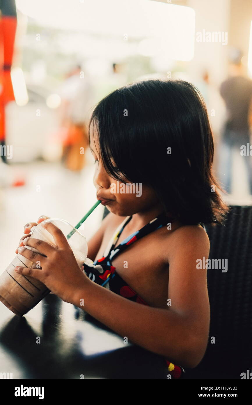 Cute little girl shake chocolat froid glace potable dans un café Banque D'Images