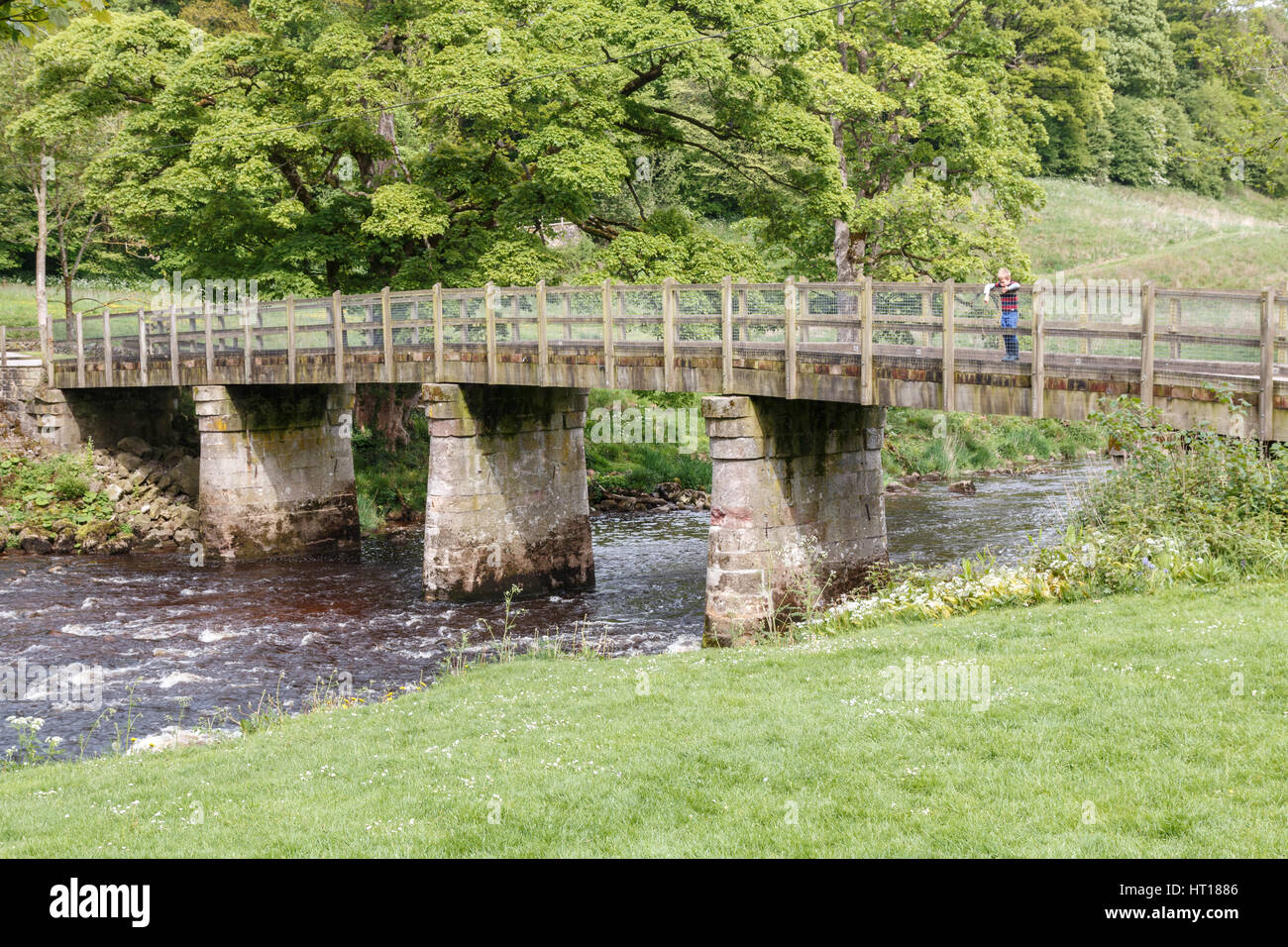 Passerelle de pierre sur la rivière Wharfe à Bolton Abbey dans le Yorkshire Dales. Le pont est construit avec la pierre calcaire locale. Banque D'Images