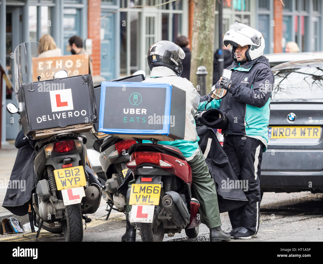 Deliveroo Et Uber Mange Chat Riders Livraison En Attendant Pour Les Commandes Pres De London S Spitalfields Market Photo Stock Alamy