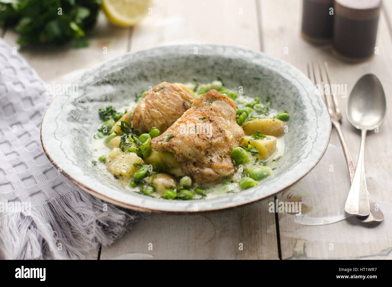 Cuisses de poulet rôti avec des fèves et des herbes Banque D'Images