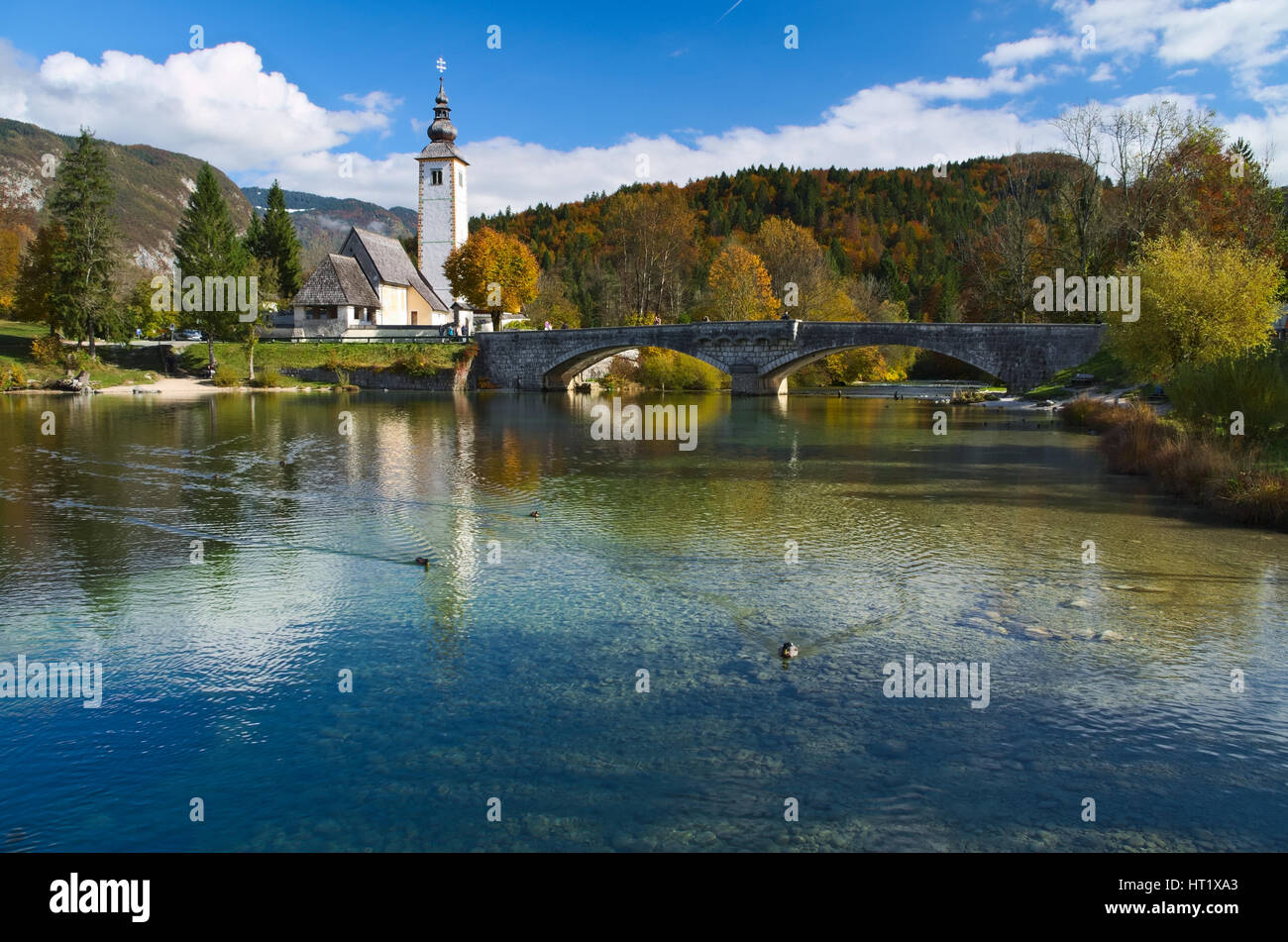 L'automne vue sur le pont de pierre et l'église de Saint-Jean le Baptiste au lac de Bohinj (bohinjsko jezero), Slovénie Banque D'Images