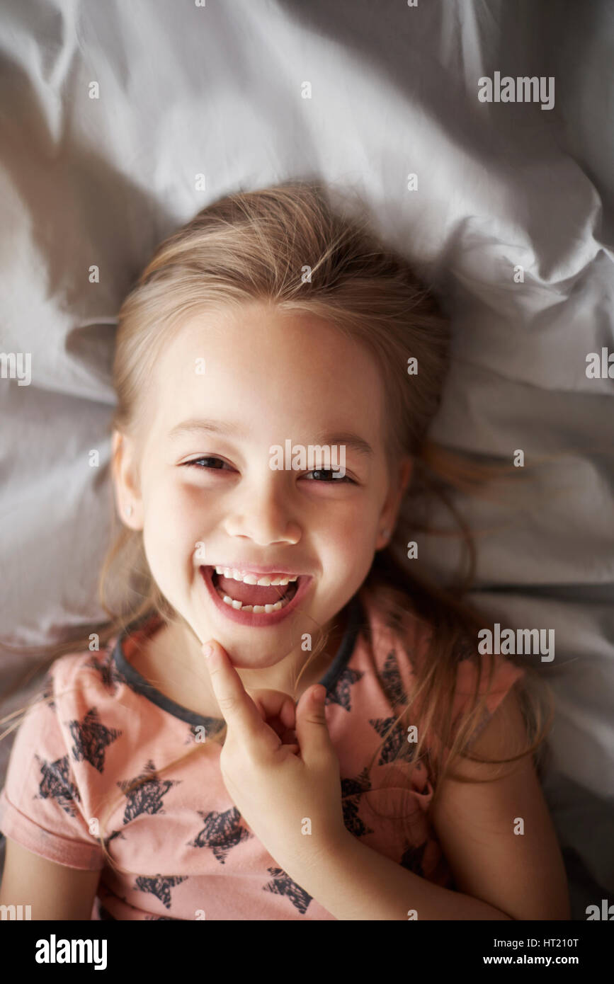 Girl rire dans son lit Banque D'Images