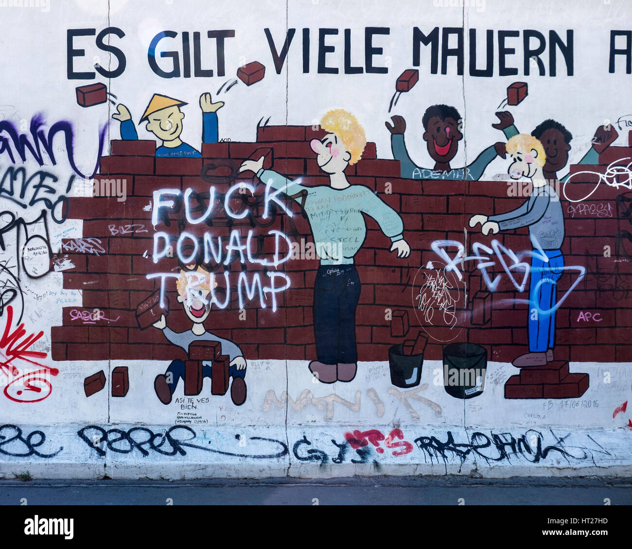 Mitte, Berlin, East Side Gallery, l'art de la rue, les gens de différentes races briser wall et anti graffiti Trump Banque D'Images