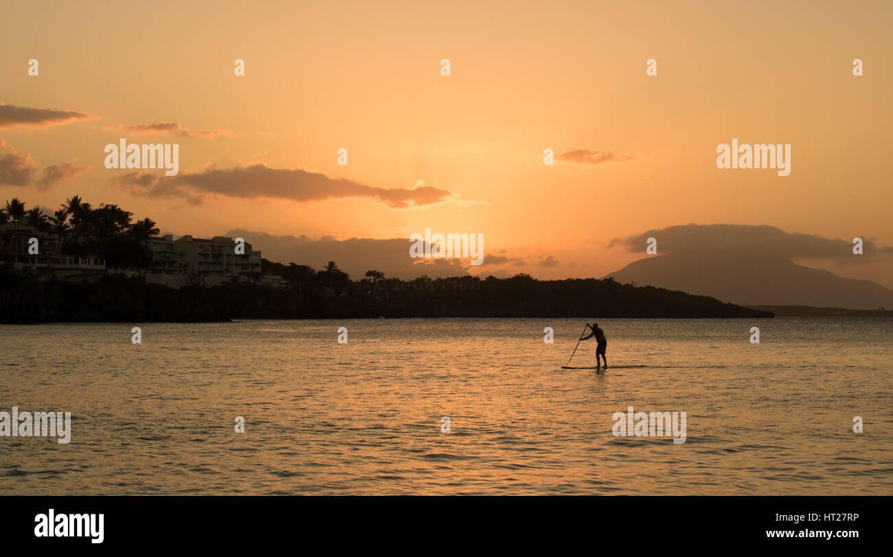 Paddleboarder paddleboarding au coucher du soleil à Sosua République Dominicaine Banque D'Images