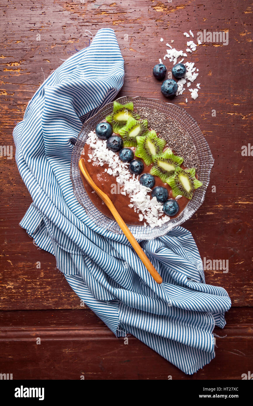 Boisson fouettée aux petits déjeuner bol garni de bleuets, kiwi, graines de chia, flocons de noix de coco pour petit-déjeuner sain, selective focus Banque D'Images