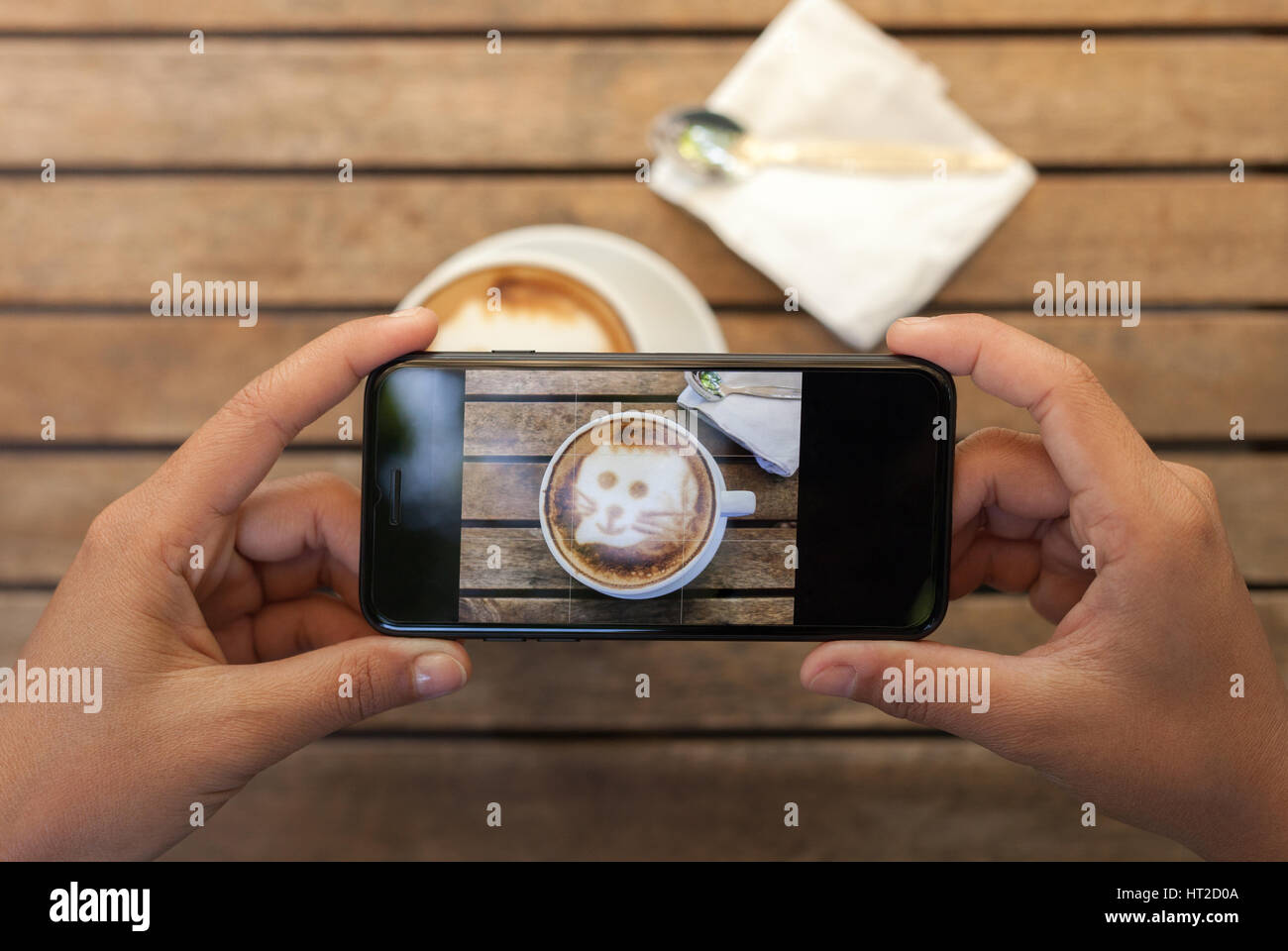 Close-up hand holding phone prenant le café photo sur tableau Banque D'Images