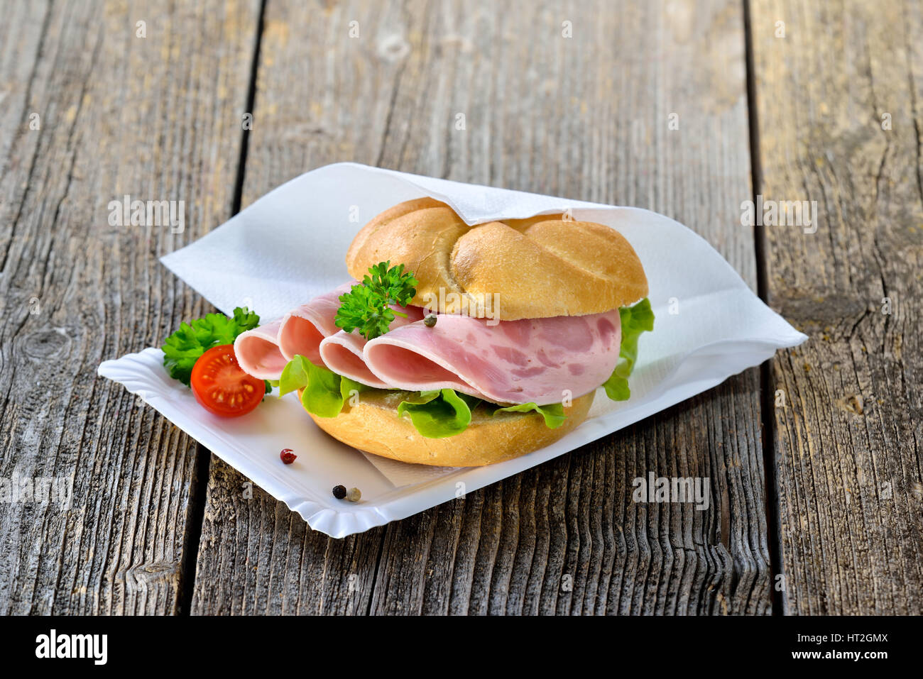 Rouleau croustillant de tranches de saucisse de jambon sur une plaque avec une serviette en papier Banque D'Images