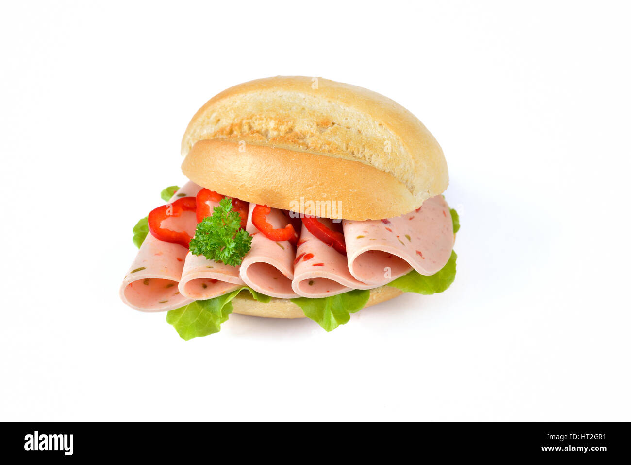 Petit pain frais avec des tranches de poivron saucisse et une feuille de laitue sur fond blanc Banque D'Images