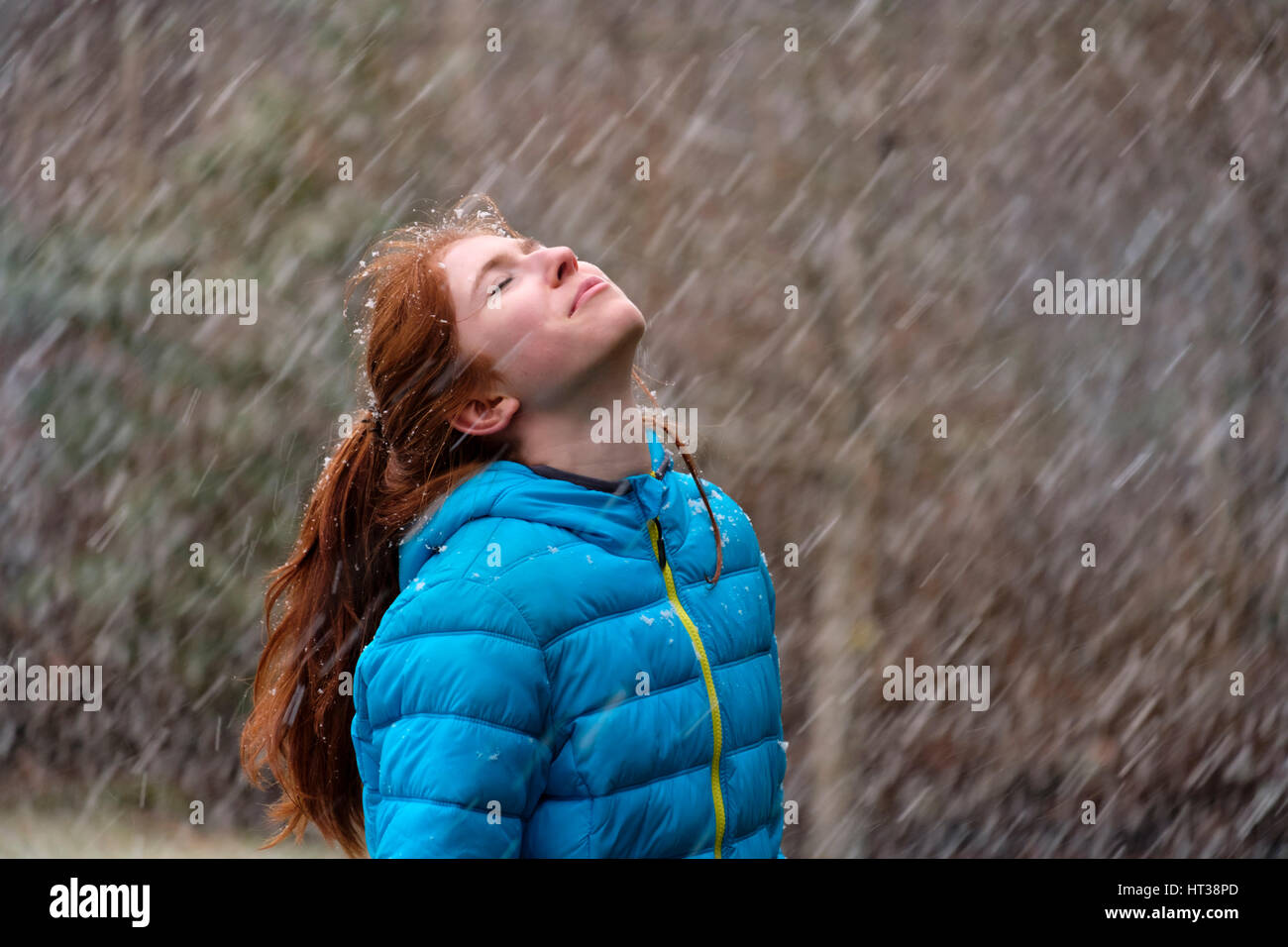 Girl bénéficiant d'épais flocons de neige en hiver, la Haute-Bavière, Bavière, Allemagne Banque D'Images
