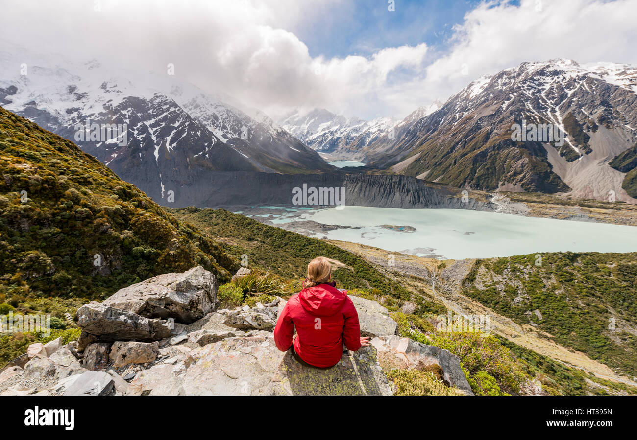 Randonneur assis sur des rochers, vue dans la vallée de Hooker Sealy Tarns Track, lacs glaciaires Mueller et le lac Hooker Lake Banque D'Images