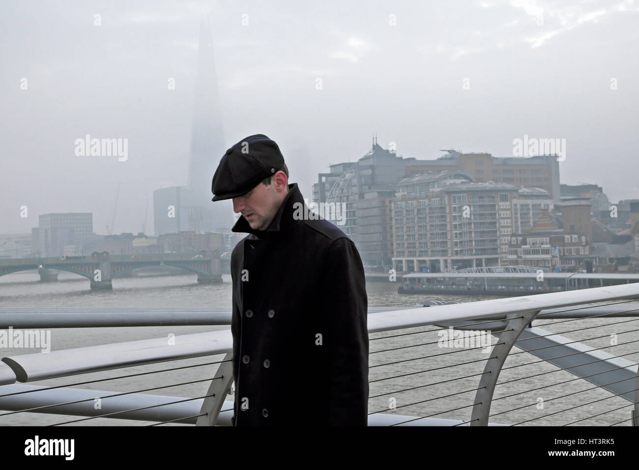 Un homme marchant sur le pont du millénaire avec une vue sur le fragment sur un jour de la pollution de l'hiver 2017, dans la ville de London, UK KATHY DEWITT Banque D'Images