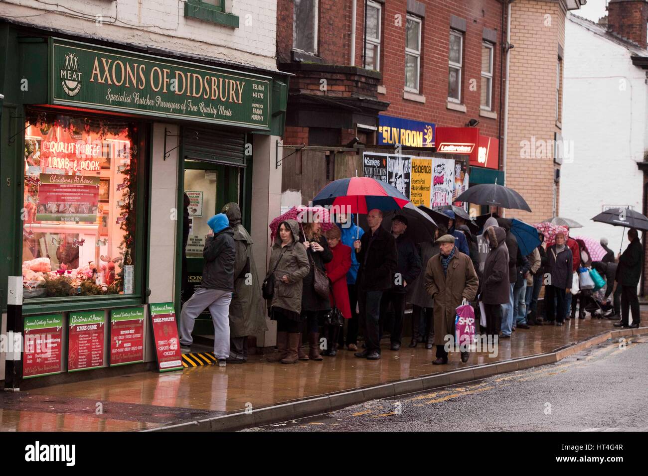 Des gens de l'extérieur de files d'une boutique de Noël à l'avance les bouchers . Les axones de Didsbury butchers Banque D'Images