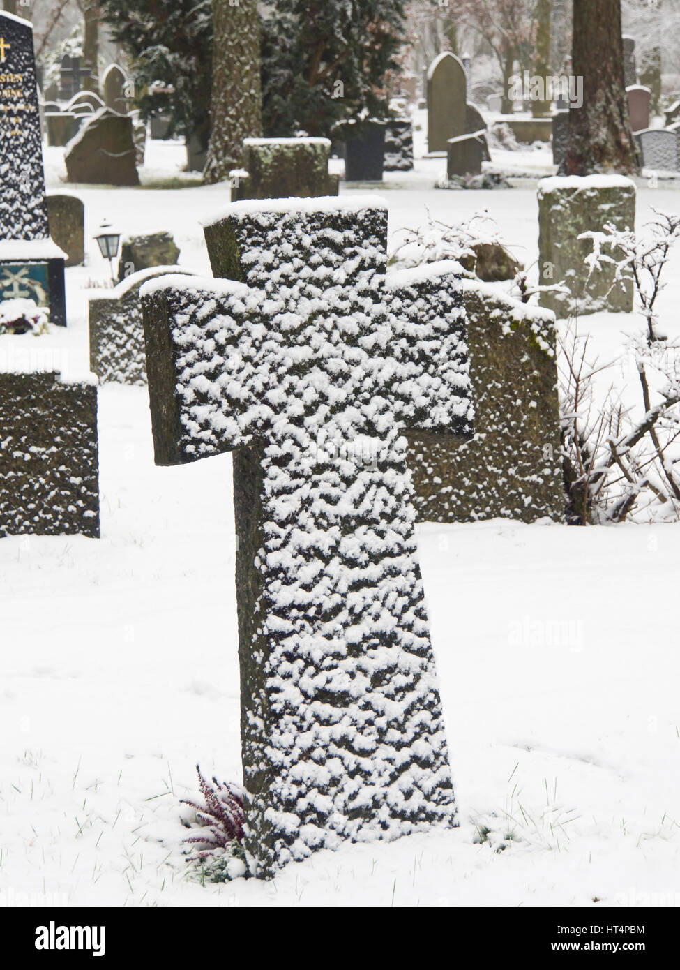 Croix de Pierre Pierre tombale dans un cimetière couvert de neige par le vent, Oslo Norvège Banque D'Images