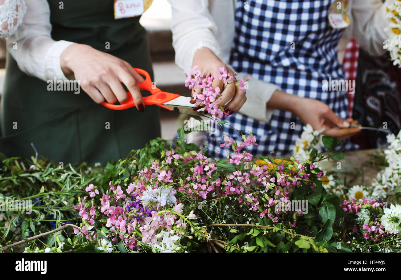 Les filles qui travaillent sur le diadème de fleurs. Processus de coupe de jardinage et de fleurs Banque D'Images