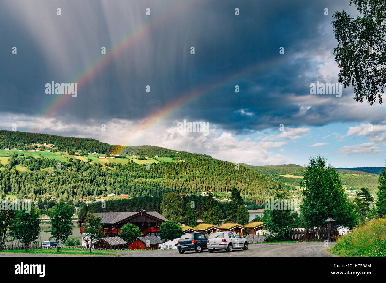 Double arc-en-ciel et nuages pluvieux inhabituel sur paysage norvégien avec camping, vacances et tourisme concept Banque D'Images