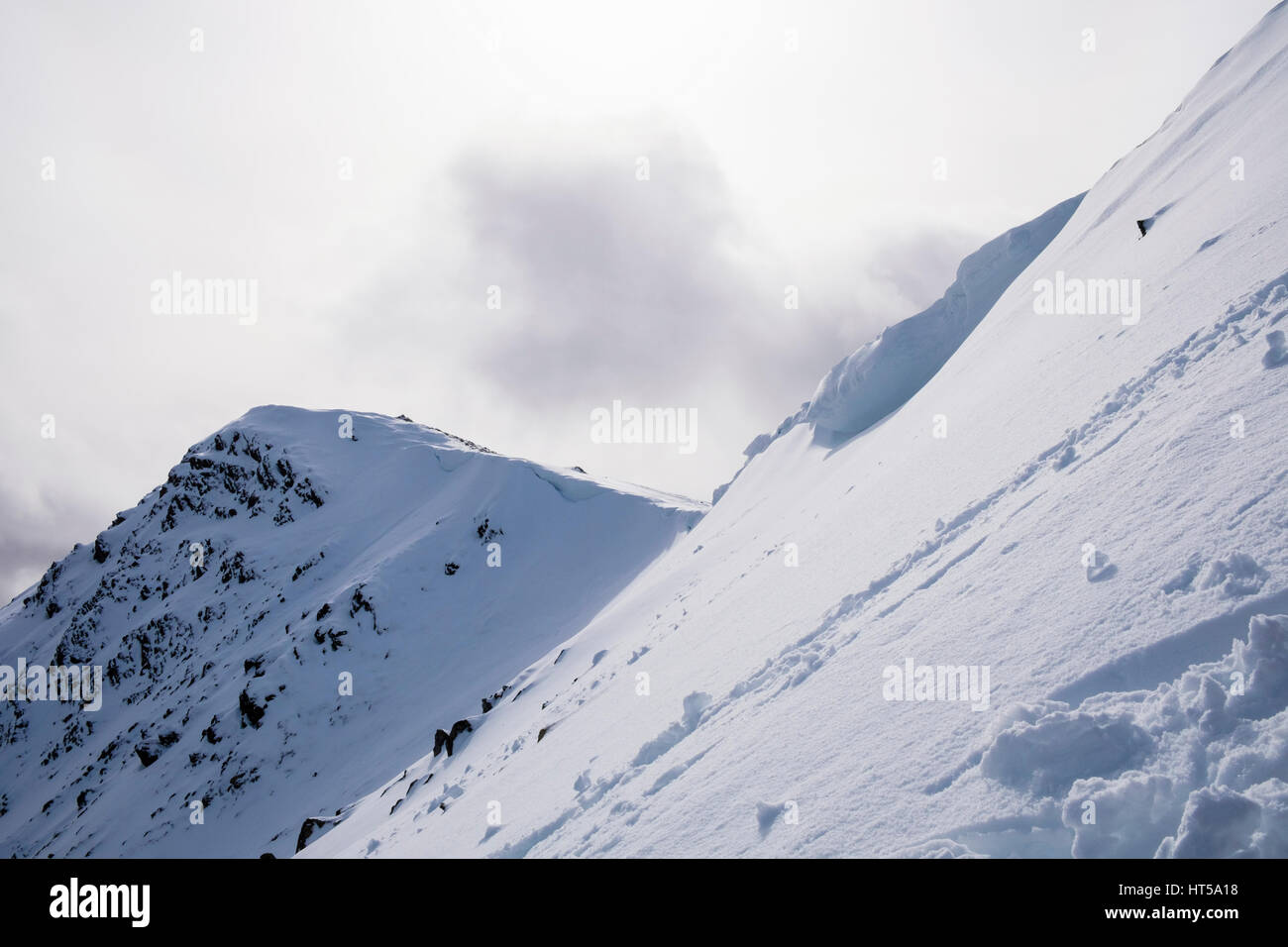 Vue d Y Garn de sommet nord-est de crête avec corniche de neige bloquant chemin dans les montagnes de Snowdonia National Park. Gwynedd, au nord du Pays de Galles, Royaume-Uni, Angleterre Banque D'Images