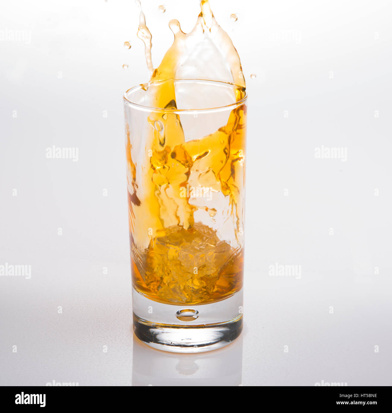 Splash en verre de whisky écossais avec des cubes de glace Banque D'Images