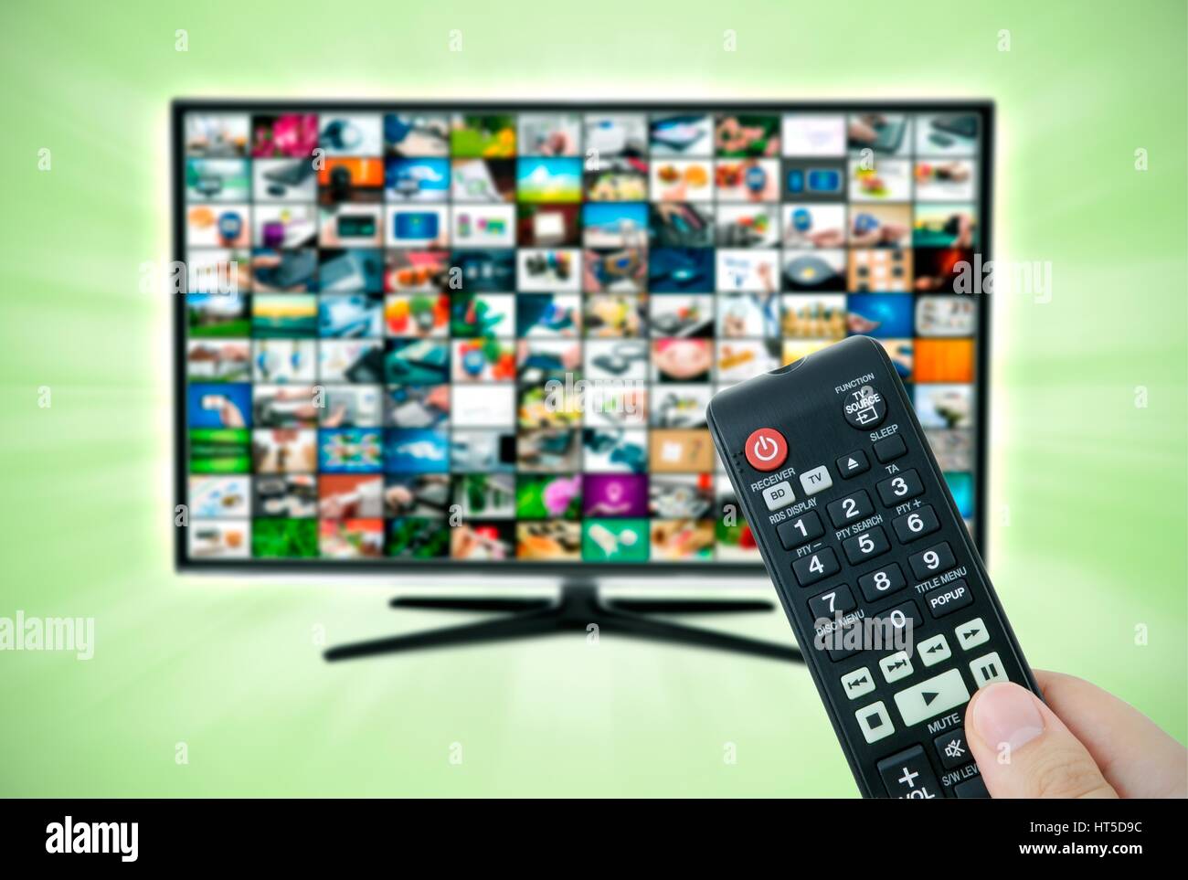 La télévision haute définition à écran large écran avec galerie de vidéos. Télécommande en main Banque D'Images