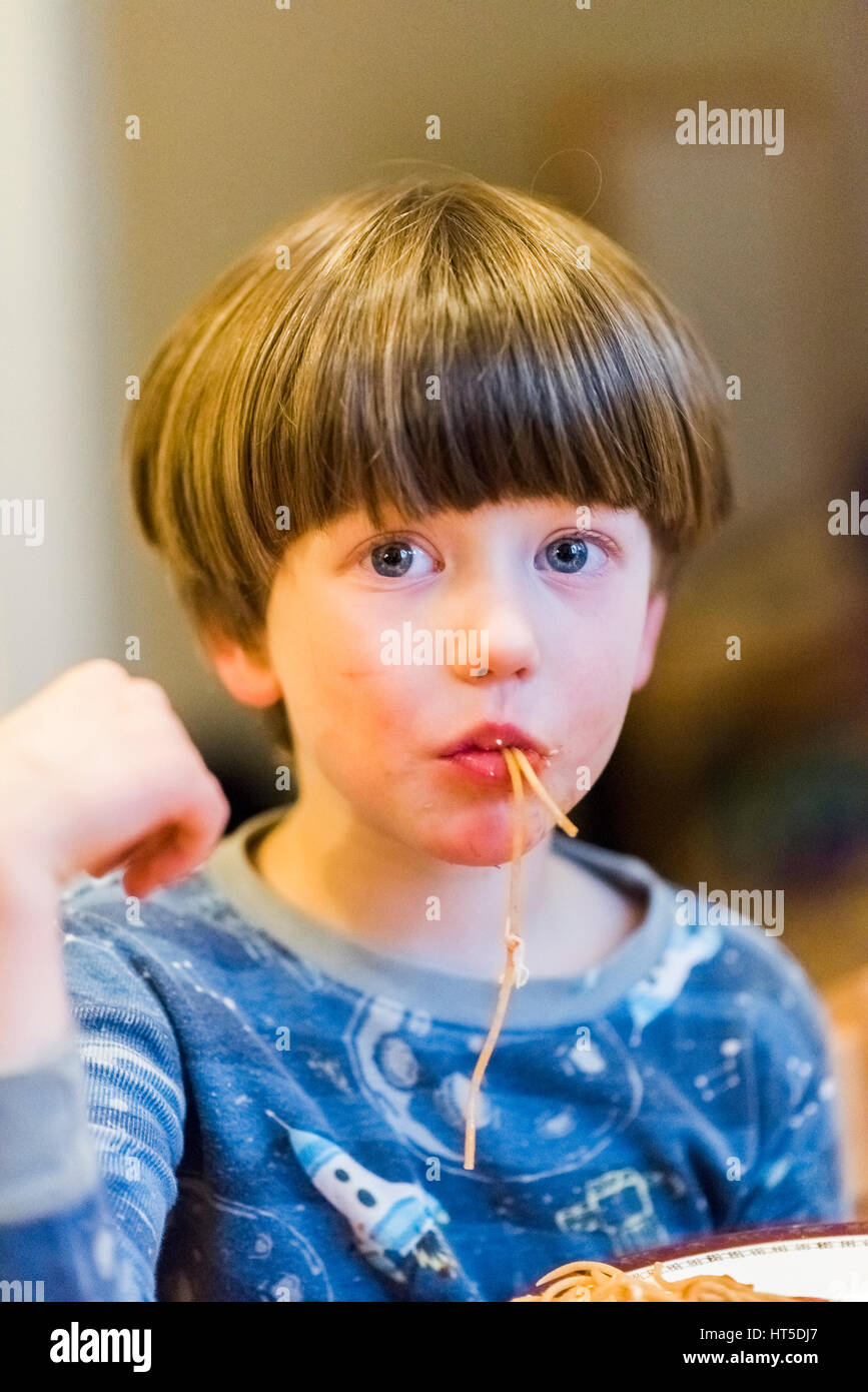 Jeune garçon mange du spaghetti salissent. Banque D'Images