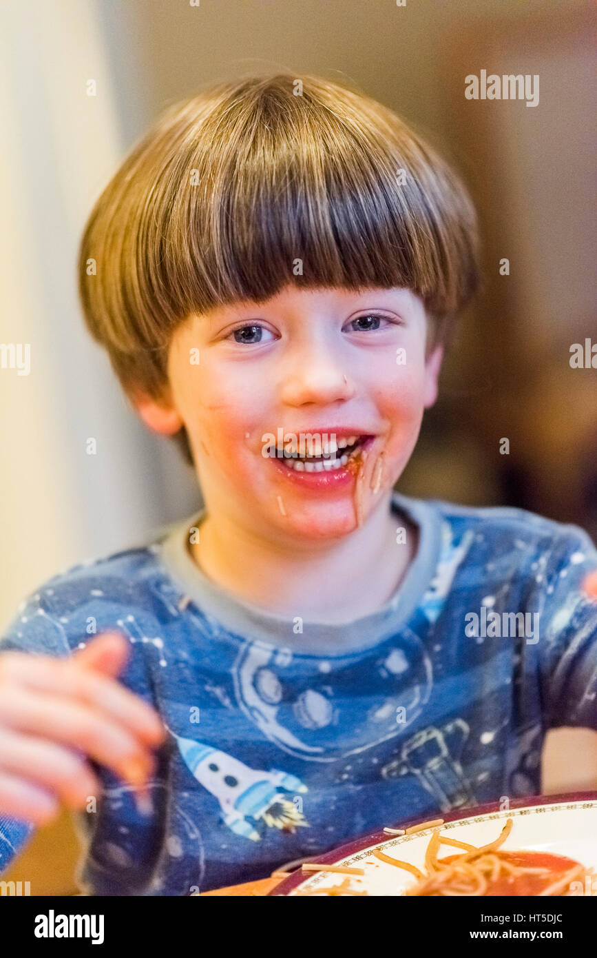 Jeune garçon mange du spaghetti salissent. Banque D'Images