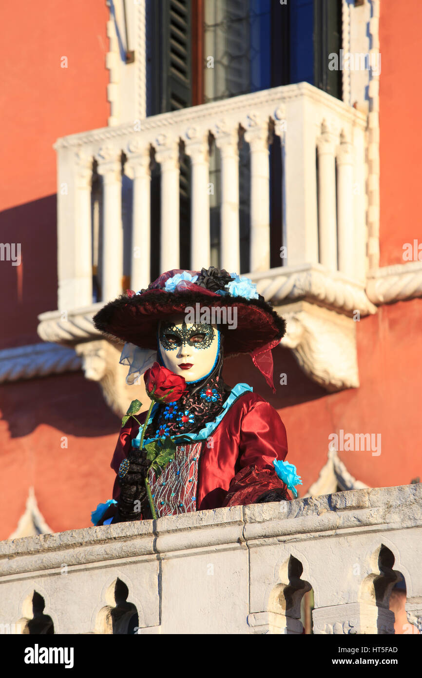 Une dame masquée dans un robe vénitien tenant une rose rouge au cours de la 2017 Carnaval de Venise, Italie Banque D'Images