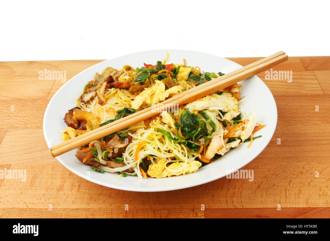Repas chinois, Singapour nouilles dans un bol avec des baguettes sur une table en bois Banque D'Images