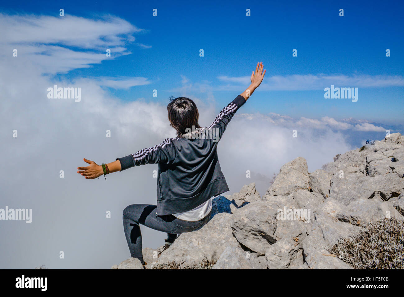 Fille sur le sommet de la montagne sur les nuages,open arms posing Banque D'Images